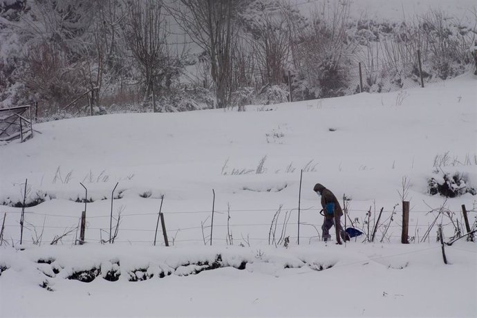 Una persona camina sobre la nieve en la parroquia de O Cebreiro, en Lugo, Galicia (España), a 29 de diciembre de 2020. El temporal de nieve ha dificultado la circulación en más de un centenar de carreteras en las provincias de Lugo y Ourense.  Paralelam