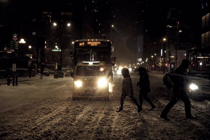 Varias personas cruzan la calle en medio de la nevada en Nueva York