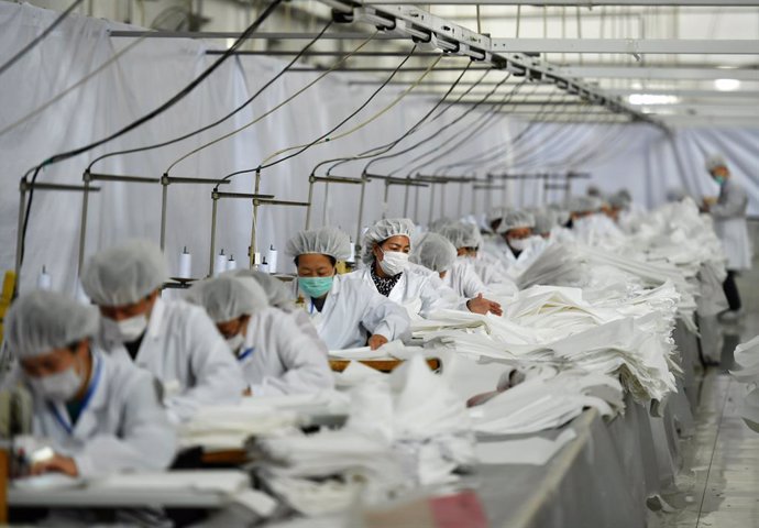 FILED - 17 February 2020, China, Shijiazhuang: Employees wear protective suits as they work to produce more than 25000 protective suits every day to send them to Wuhan during the current Coronavirus outbreak. Photo: -/TPG via ZUMA Press/dpa