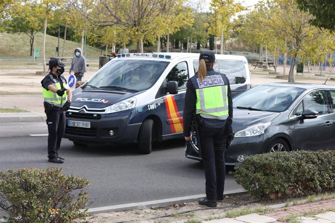 Un agente de la Policía Nacional para un vehículo en Alcorcón.