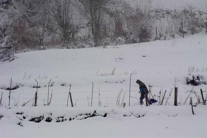 Foto de archivo de una persona camina sobre la nieve.