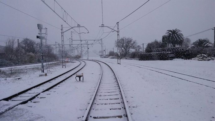 Vías de tren cubiertas por la nieve en una foto de archivo