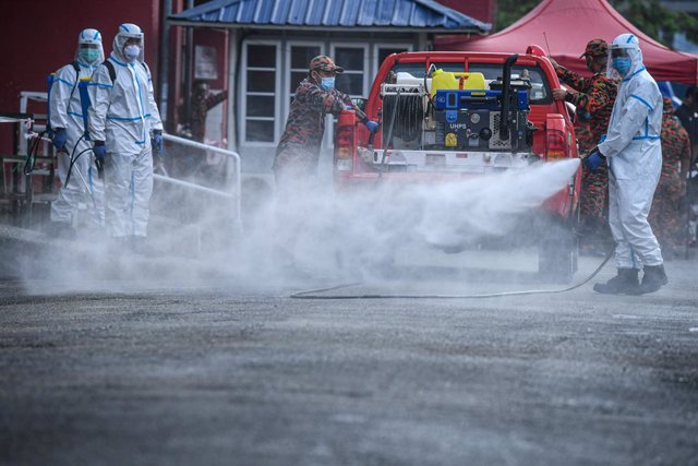 Trabajadores desinfectando una calle en una ciudad de Malasia