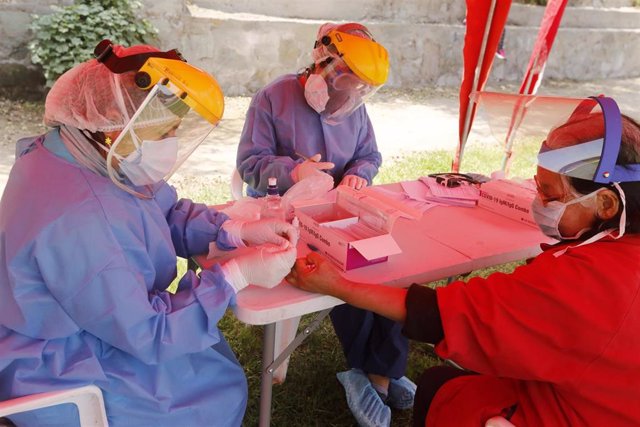 Una trabajadora sanitaria realiza pruebas rápidas del coronavirus en Perú.
