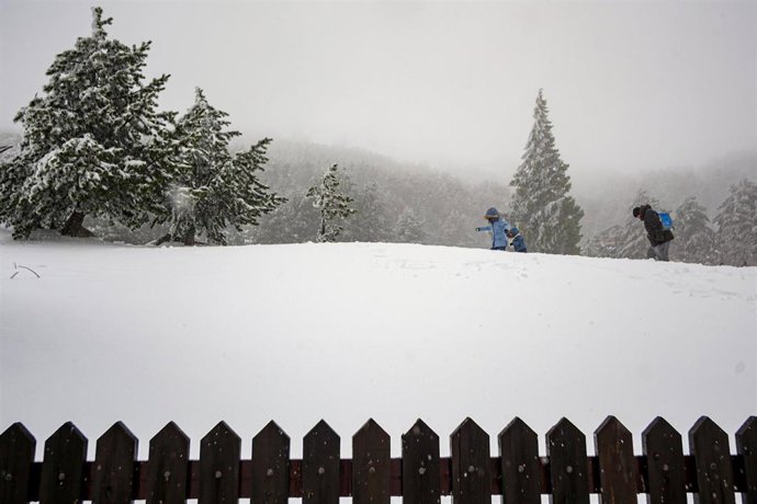Varias personas caminan por la montaña durante el temporal de nieve en la Sierra de Madrid, en el Puerto de Navacerrada (Madrid) a 16 de noviembre de 2019.