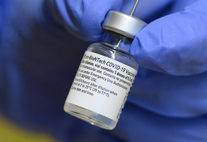 FILED - 04 January 2021, Saxony, Dresden: An employee at the Dresden Municipal Hospital holds an injection vial containing the Biontech/Pfizer vaccine against Coronavirus in the vaccination centre for employees. The EuropeanCommission has doubled its o