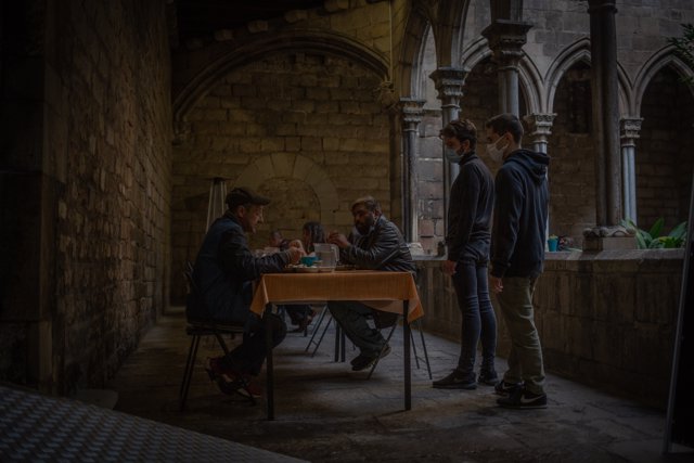 Varias personas sin techo comen en las instalaciones del Hospital de campaña instalado en la parroquia de Santa Anna, en Barcelona, Catalunya, (España), a 14 de noviembre de 2020. 