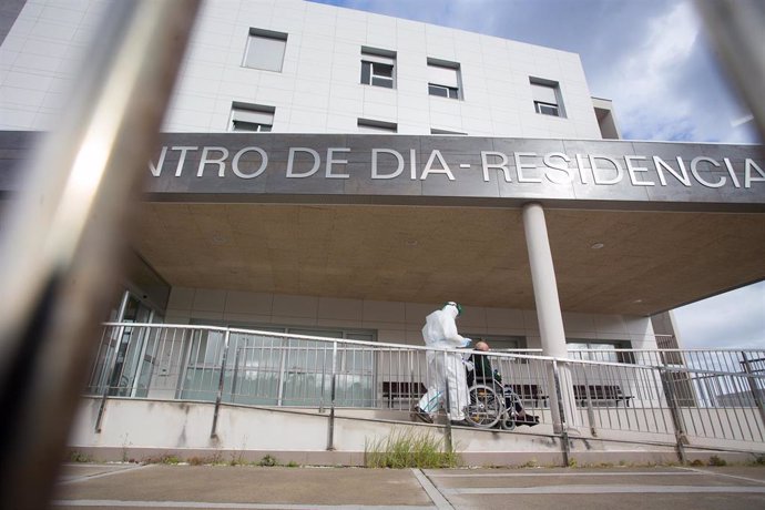 Un trabajador sanitario totalmente protegido acuden a buscar a un anciano de la residencia de ancianos de San Cibrao donde se ha originado un brote de Covid-19, en San Cibrao, Lugo, Galicia, (España), a 9 de noviembre de 2020. En el centro la situación 