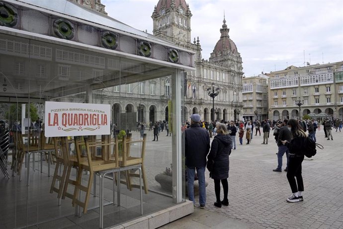 Grupos de personas se concentran en fila de a cuatro en la plaza de María Pita contra las restricciones impuestas al sector hostelero, en A Coruña