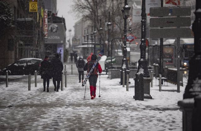 Un hombre camina con un equipo para esquiar en el segundo día de nieve en la capital tras el paso de la borrasca Filomena, en Madrid (España), a 8 de enero de 2021. 
