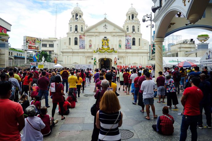 09 January 2021, Philippines, Manila: Hundreds of devotee take part in a mass outside the Minor Basilica of the Black Nazarene. People attend the mass in batches instead of parading with the Black Jesus of Nazarene due to the coronavirus pandemic. Photo
