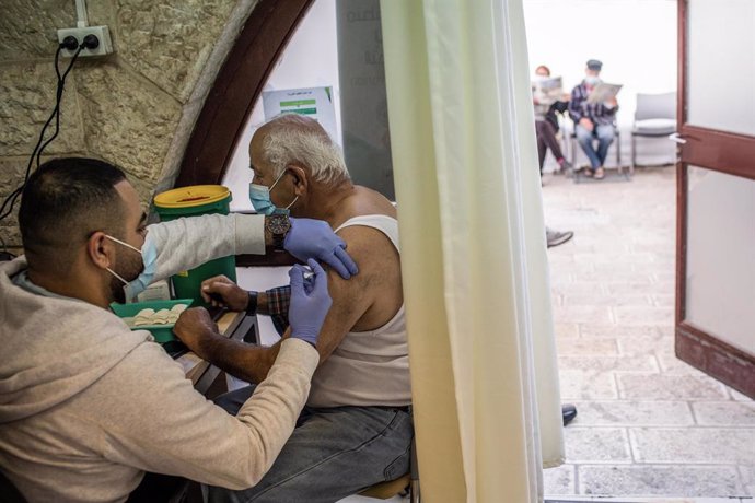 04 January 2021, Israel, Jerusalem: A man receives a Coronavirus (COVID-19) vaccine from medical personnel at a vaccination center in Jerusalem. Israel has vaccinated 1 million people, two weeks after the launch of its Covid-19 inoculation campaign. Pho