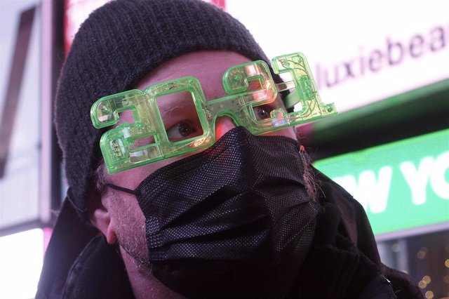 Un hombre con mascarilla y gafas de 2021 celebra el Año Nuevo en Times Square, Nueva York, Estados Unidos
