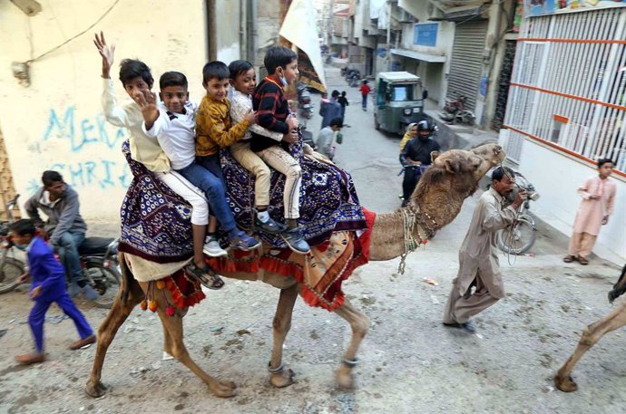 25 December 2020, Pakistan, Karatschi: Children from the Christian community ride a camel in Mehmoodabad district on Christmas Day. Photo: Ppi aju/PPI via ZUMA Wire/dpa