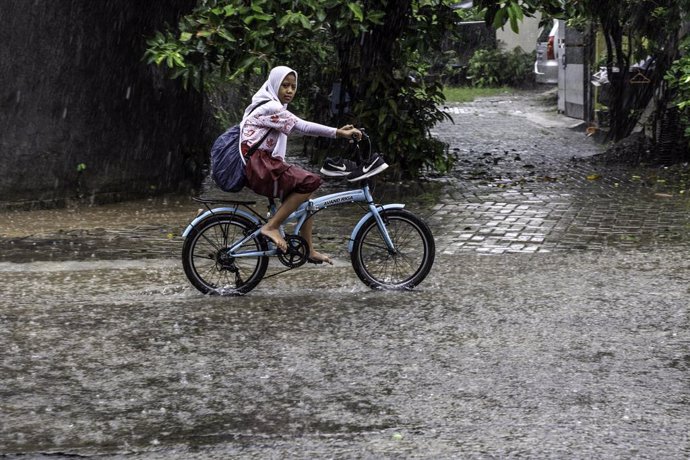 22 January 2019, Indonesia, South Tangerang: A girl rides a bicycle during a heavy rain. Photo: Donal Husni/ZUMA Wire/dpa