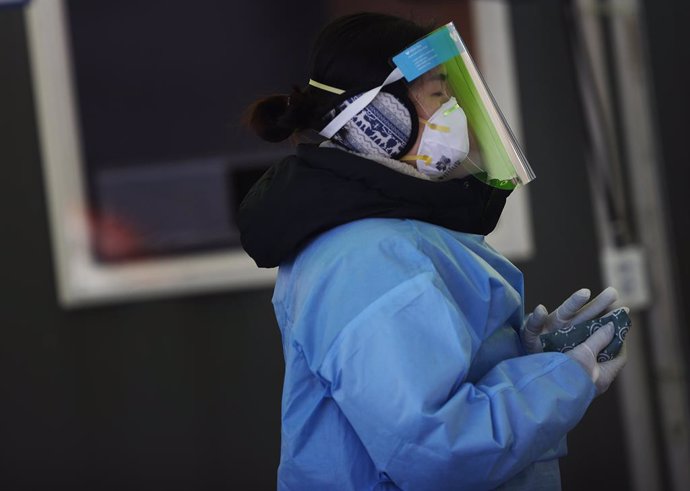 10 January 2021, South Korea, Seoul: A medical worker warms her hands with instant hot packs at a makeshift clinic for coronavirus testing in front of Seoul Station amid a cold wave sweeping the country. Photo: -/YNA/dpa