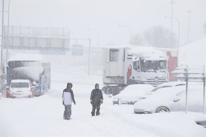 Dos personas en el que varios vehículos, entre ellos un camión y un autobús de línea municipal, han quedado atrapados en una de las carreteras de acceso al distrito de Hortaleza, en Madrid (España) a 9 de enero de 2021.