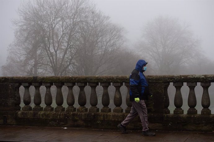 09 January 2021, England, Warwick: A man wearing a face mask walks during freezing fog in Warwick. Photo: Jacob King/PA Wire/dpa