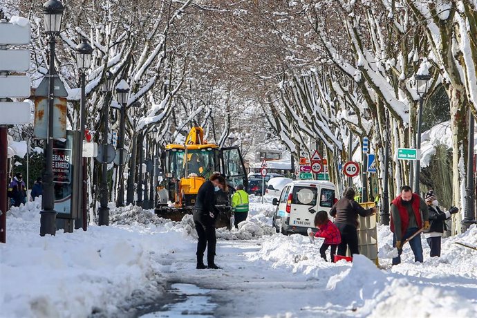 Varias personas despejan el camino tras el paso de la nevada fruto del temporal Filomena, en Pozuelo de Alarcón, Madrid (España), a 10 de enero de 2021. La Comunidad de Madrid ha mantenido desplegado en las últimas 48 horas un dispositivo de coordinació