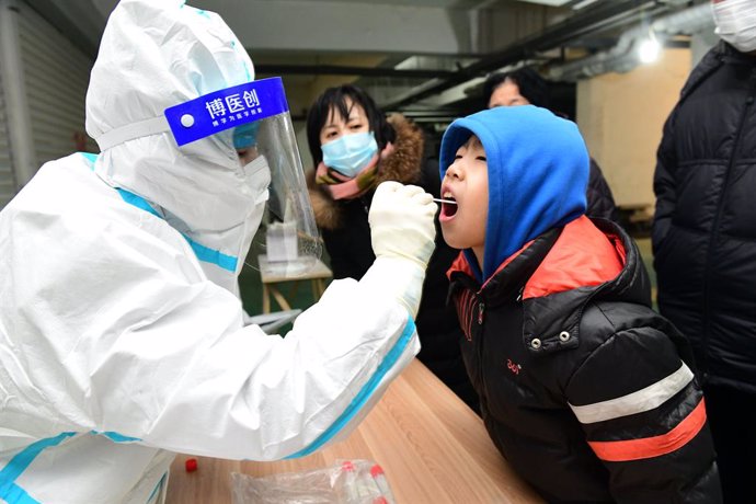 06 January 2021, China, Shijiazhuang: A health worker takes a swab from a child for coronavirus (COVID-19) test. Photo: -/TPG via ZUMA Press/dpa