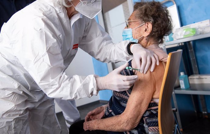 10 January 2021, Bavaria, Pfaffenhofen a.d.Ilm: An employee of the Bavarian Red Cross (BRK) injects 100-year-old Juliana Pauler with the Biontech/Pfizer COVID-19 vaccine at a vaccination center. Photo: Sven Hoppe/dpa