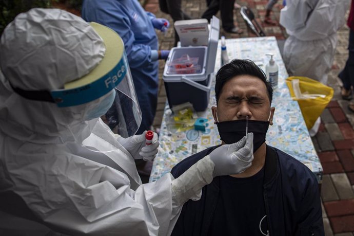 07 January 2021, Indonesia, South Jakarta: A health worker takes a swab from a man for coronavirus test at Public Health Ciganjur. Indonesia tightens coronavirus restrictions after the rising in infections as it reached 8854 cases on Wednesday. Photo: D