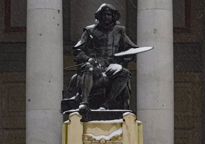 La figura del pintor Velázquez cubierta de nieve frente al Museo del Prado