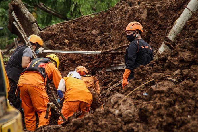 10 January 2021, Indonesia, Sumedang: Members of a rescue team look for bodies of victims or survivors who were buried by a landslide that occurred due to heavy rainfall and unstable soil conditions. Photo: Algi Febri Sugita/SOPA Images via ZUMA Wire/dpa