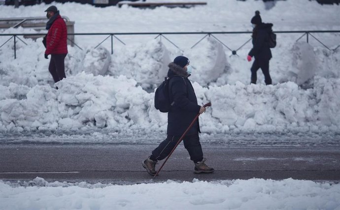 Varias personas caminan por el hielo que ha dejado la nieve alrededor de la Estación de Renfe de Alcorcón, en Madrid