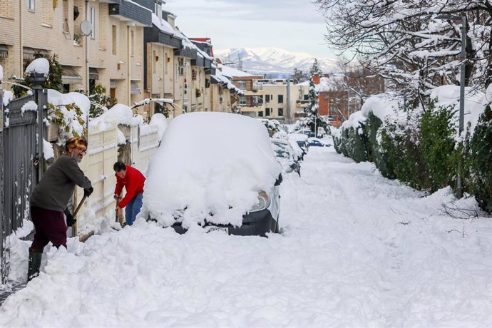 Dos personas despejan el camino con palas tras la nevada fruto del temporal Filomena, en Madrid.