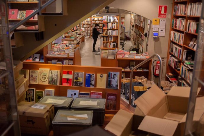 Trabajadores de la librería Laie Pau Claris colocan libros y material en las estanterías del local que permanece cerrado al público por la crisis del Covid-19. En Barcelona, Cataluña, (España), a 22 de abril de 2020.
