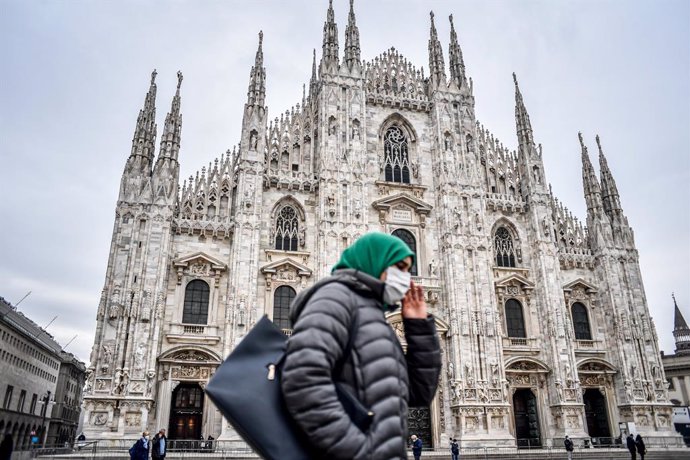 22 October 2020, Italy, Milan: A woman walks past the Milan Cathedral wearing a face mask. Photo: Claudio Furlan/LaPresse via ZUMA Press/dpa