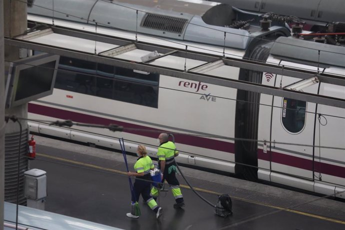 Dos trabajadores caminan por un andén en la estación de Atocha