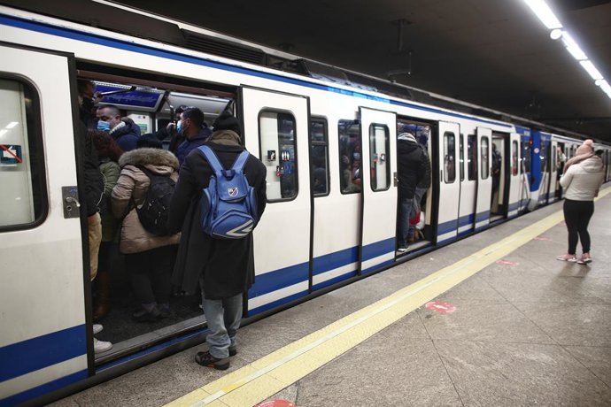 Gente entrando a un vagón parado en el andén de la estación de metro de Atocha Renfe.