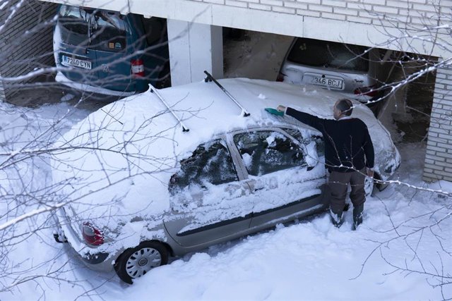 Un hombre retira la nieve que hay sobre su coche tras el paso de la nevada fruto del temporal Filomena por la Comunidad de Madrid.