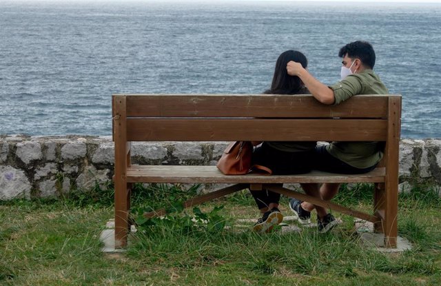 Una pareja sentada con mascarillas en LLanes, Asturias.