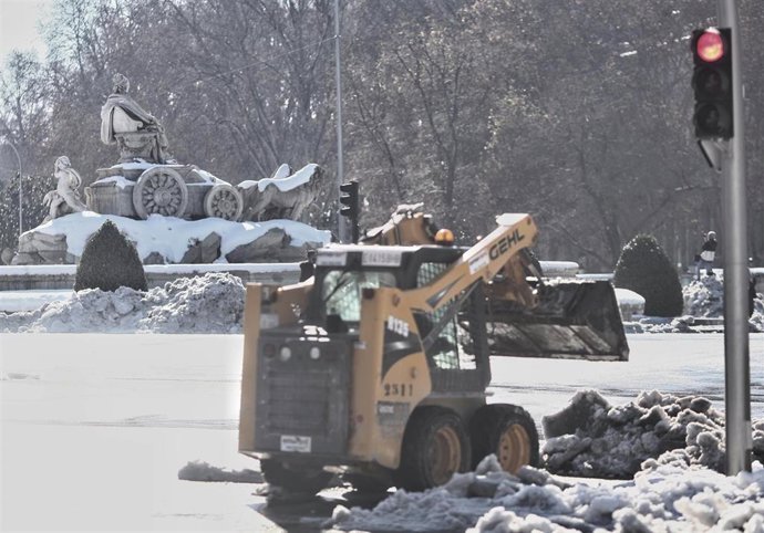 Un operario trabaja con una máquina quitanieves en la Plaza de Cibeles