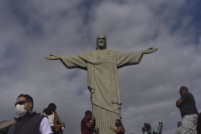 Personas con mascarilla por el coronavirus junto al Cristo del Corcovado de Río de Janeiro