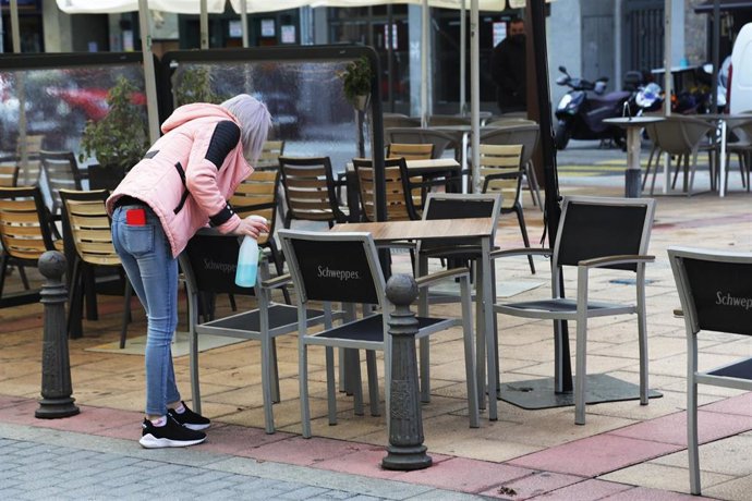 Una camarera desinfecta una mesa en León.