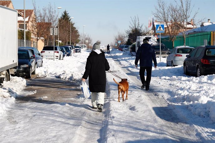 Varias personas caminan por una de las carreteras llenas de nieve y hielo tras el paso de la borrasca 'Filomena', en Valdemoro, Madrid (España), a 12 de enero de 2021. El dispositivo de limpieza de nieve en calles puesto en marcha por el Ayuntamiento y 