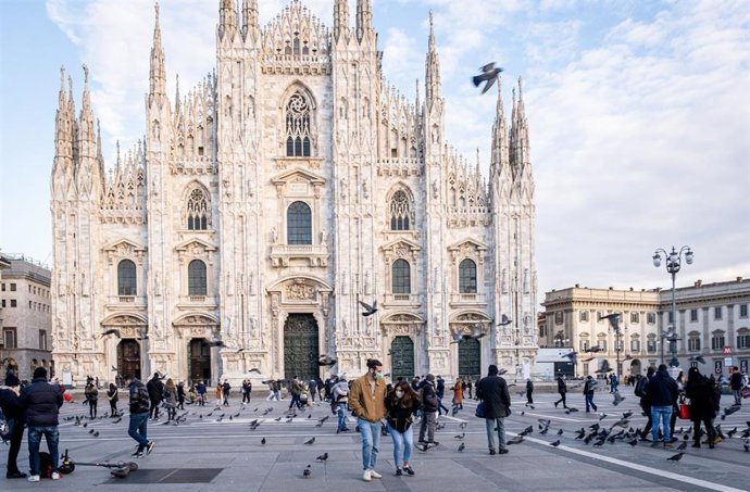 Personas con mascarillas ante la catedral de Milán
