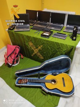 Los ordenadores y la guitarra recuperados por la Guardia Civil.