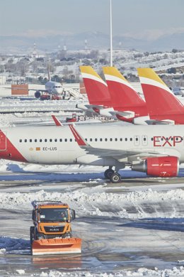 Una excavadora trabaja para retirar la nieve y el hielo de la pista del aeropuerto Madrid-Barajas Adolfo Suárez.