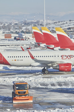 Una excavadora trabaja para retirar la nieve y el hielo de la pista del aeropuerto Madrid-Barajas Adolfo Suárez.