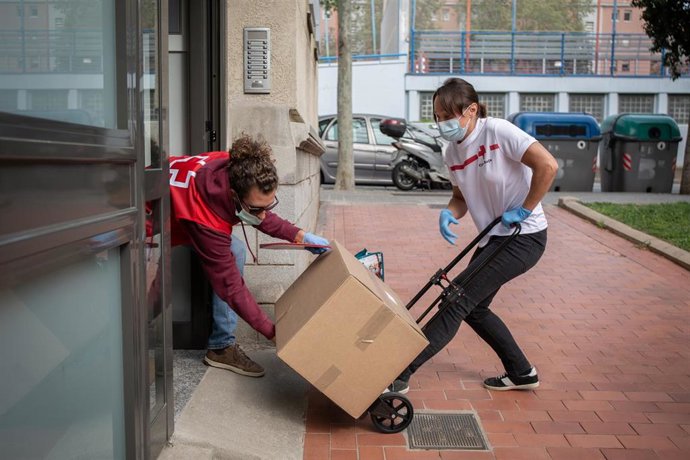 Varios voluntarios de Cruz Roja reparten cajas con alimentos y productos a todas aquellas personas que puedan verse afectadas por la crisis sanitaria del coronavirus en España. En Barcelona, Catalunya, (España), a 9 de abril de 2020.