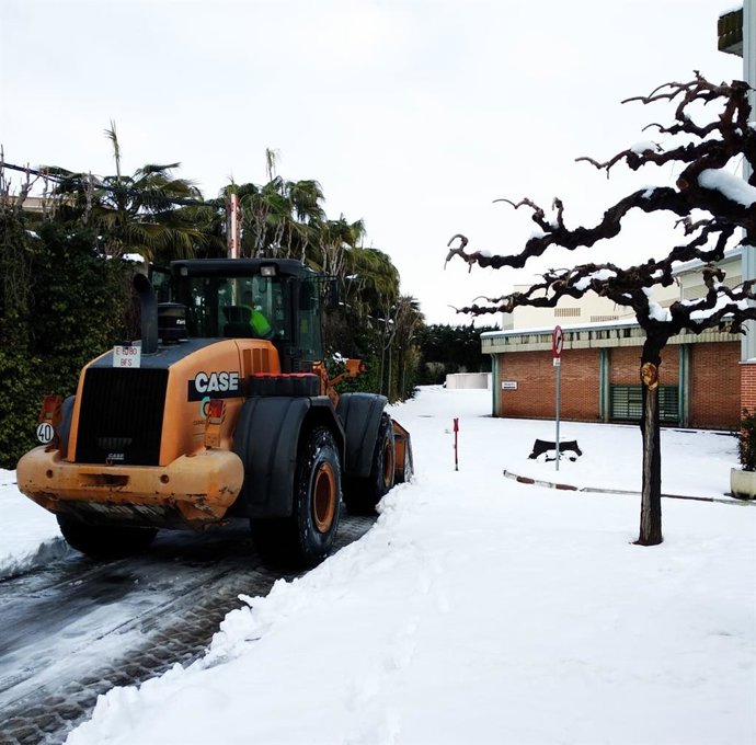 Trabajos para despejar la nieve en el acceso a un colegio.