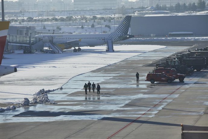 Varios militares de la Unidad Militar de Emergencia (UME) caminan por la pista del aeropuerto Madrid-Barajas Adolfo Suárez.