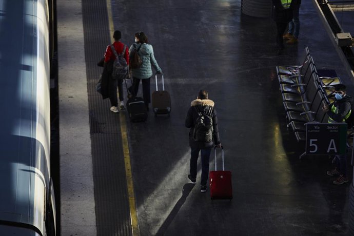 Pasajeros en un andén de uno de los trenes del AVE, en la Estación de Madrid-Puerta de Atocha, en Madrid (España)