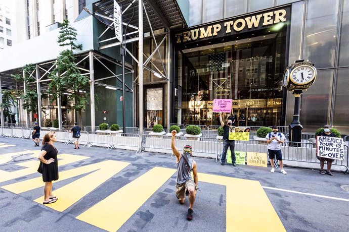 09 July 2020, US, New York: An activist takes a knee over a Black Lives Matter mural in front of Trump Tower on Fifth Avenue in New York city. Photo: Michael Brochstein/ZUMA Wire/dpa