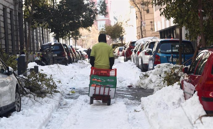 Un hombre arrastra una carretilla por una calle del centro aún con nieve y árboles caídos en Madrid (España), a 13 de enero de 2021. Madrid sigue cubierto de nieve cinco días después de la gran nevada provocada por el paso de la borrasca Filomena. El 
